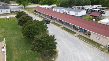 A mobile home park with single-story buildings, a paved road, and RVs parked.