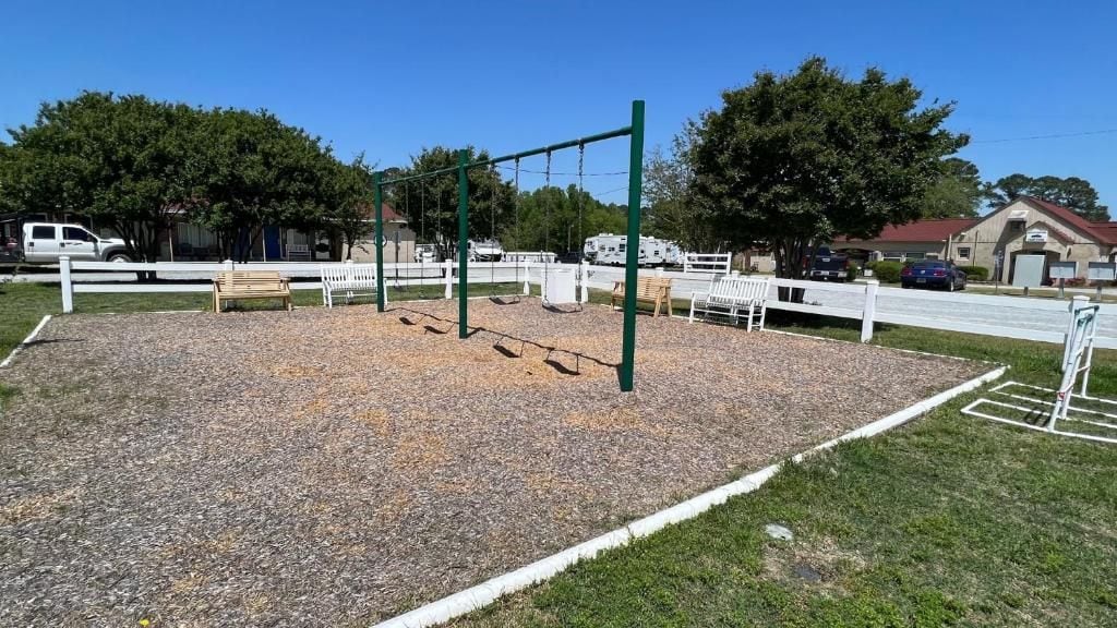 Ein Spielplatz im Freien mit Schaukeln und einer Kletteranlage.