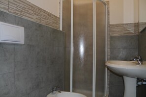 A bathroom with a shower, a sink, and a toilet. - Cagliari 4u (Cagliari)