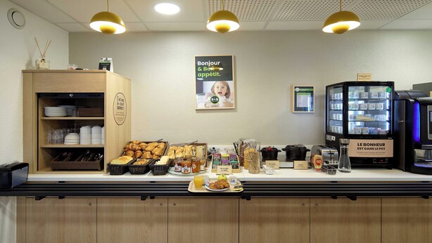 Ein Frühstücksbuffet mit verschiedenen Speisen und einer Kaffeemaschine.