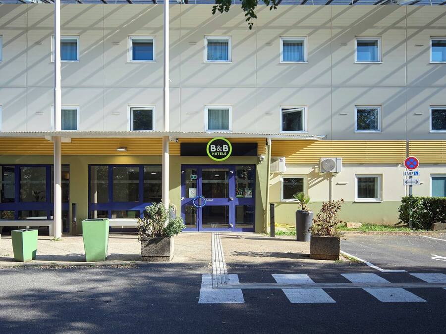Un hotel con fachada moderna, entrada azul y cartel que indica que es un B&B.