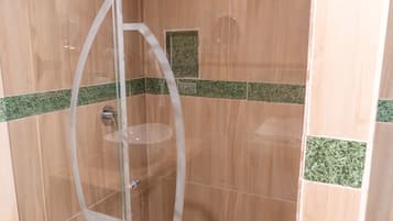Une douche entièrementClose avec des parois en verre, un sol en bois et des touches de couleur grâce à des carreaux verts.