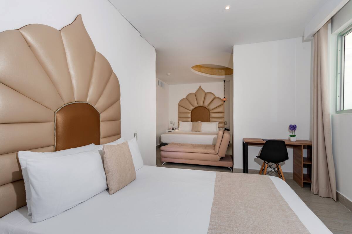 Une chambre d’hôtel moderne dotée d’un grand lit, d’un bureau et offrant une vue sur la ville.