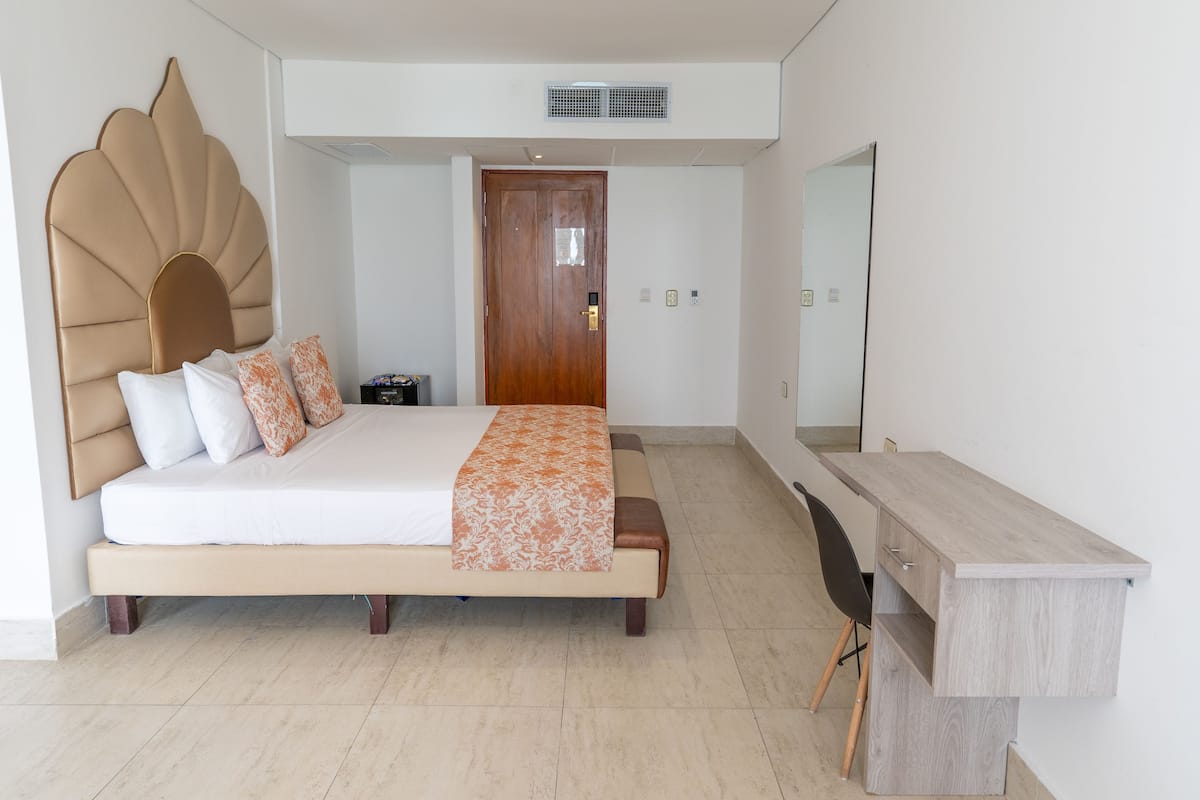 Une chambre à coucher moderne avec un grand lit, un bureau et un miroir.