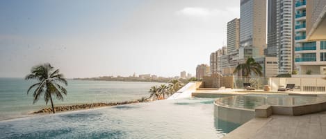 Una piscina al aire libre, sillones reclinables de piscina