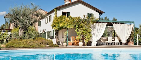 Una piscina al aire libre de temporada, sombrillas