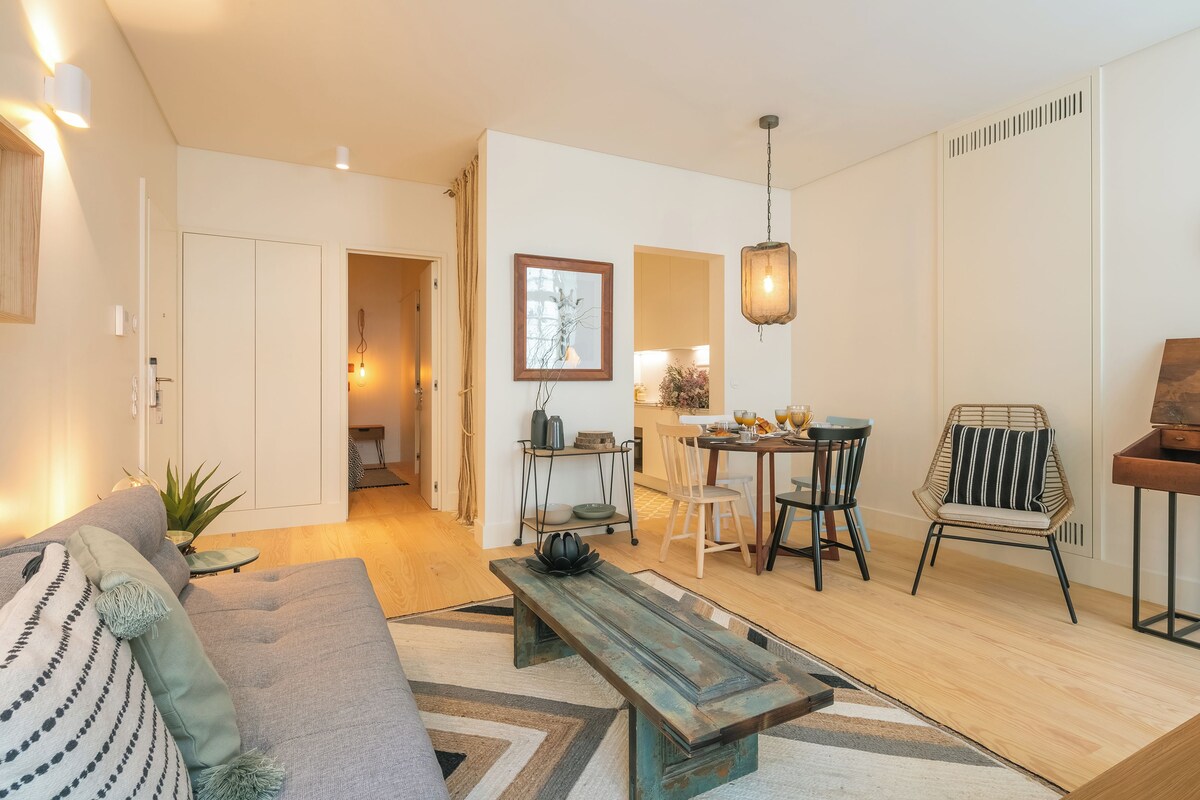 Un salon moderne comprenant un canapé, une table basse et un coin repas avec des chaises et une table.