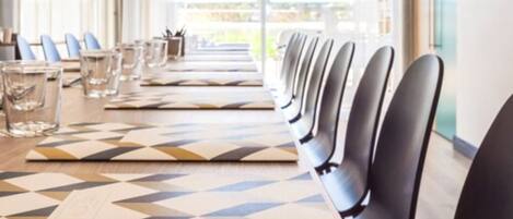 A conference room with a long table, chairs, and glassware.