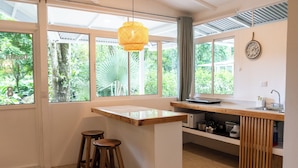 Una cocina moderna con ventanas amplias, una isla de madera y taburetes de bar.