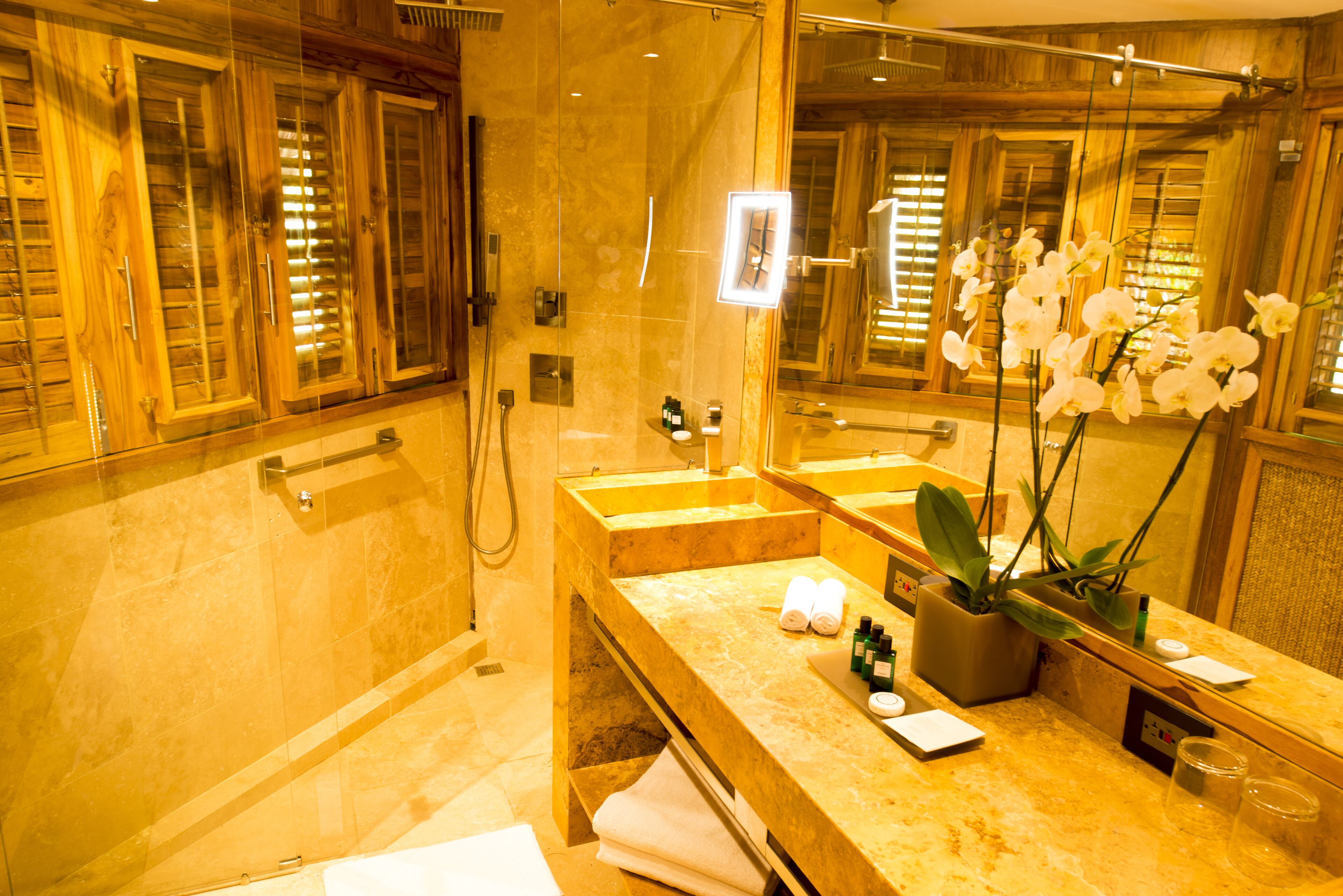 Een badkamer met een grote spiegel, een wastafel en een douche.