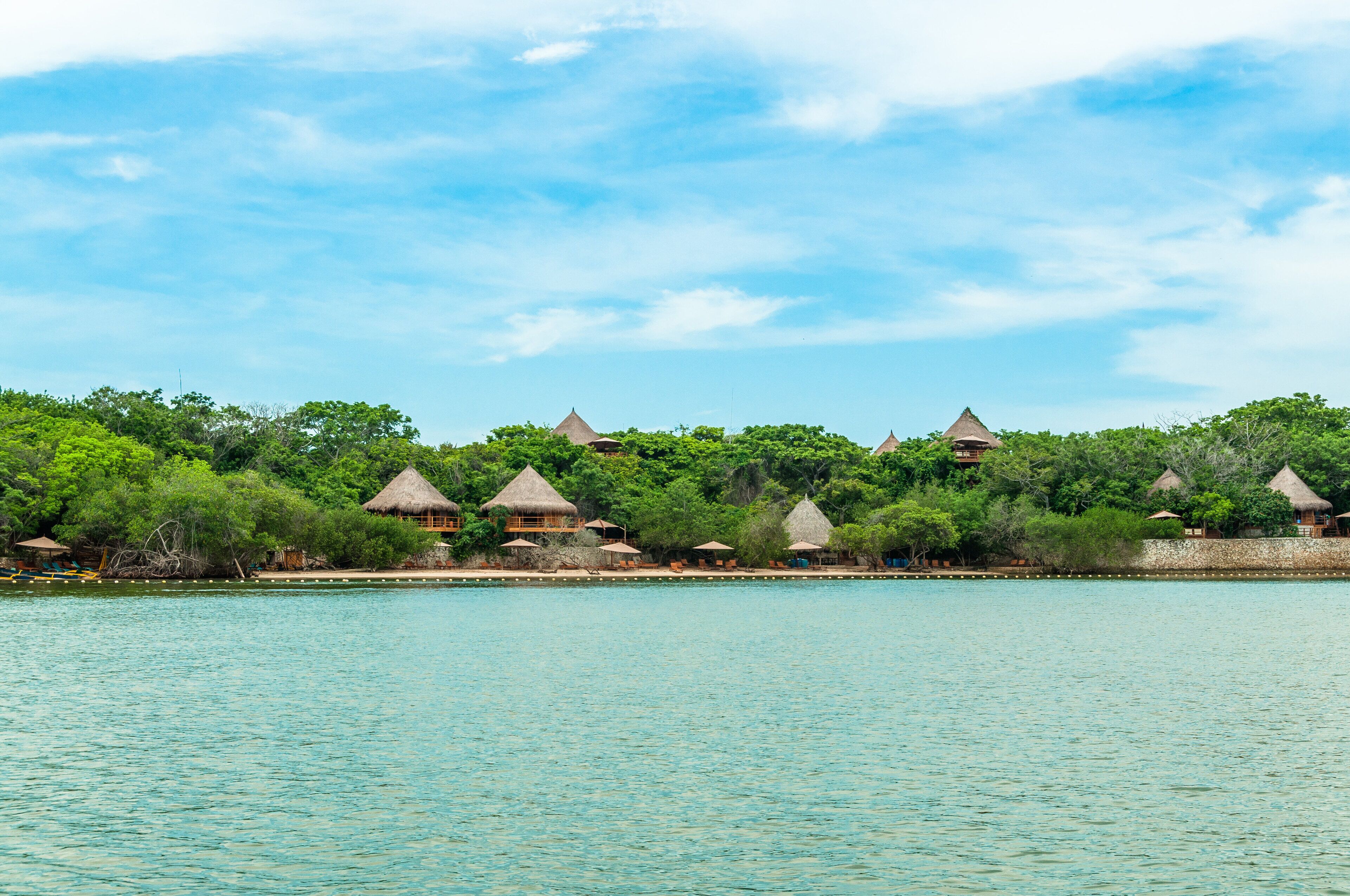 A coastal resort with thatched-roof villas overlooking turquoise waters.