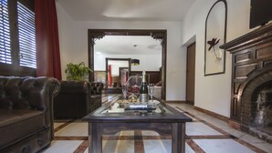 Una sala de estar con un sofá de cuero, una mesa de centro de vidrio y una chimenea.