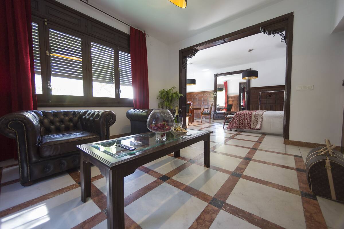 A living room with a leather sofa, a glass coffee table, and a checkered floor.