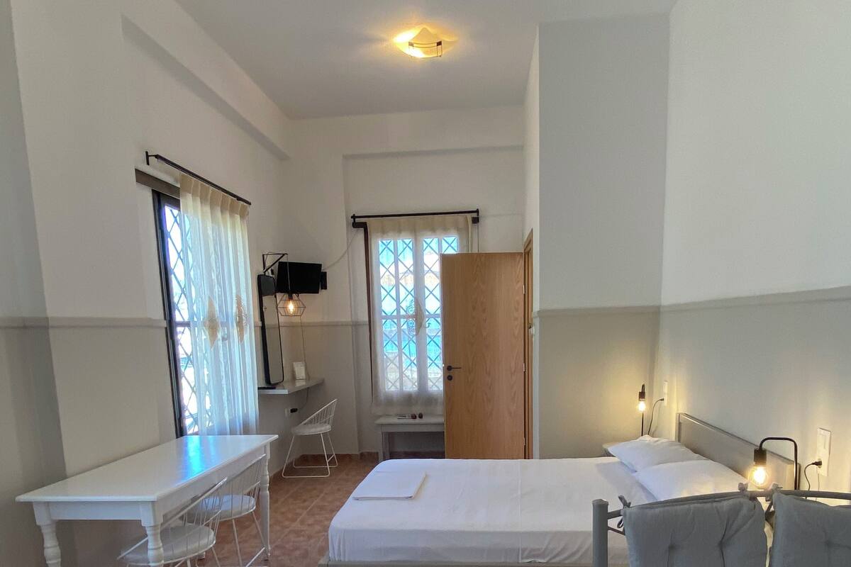 A room with a bed, a desk, and a chair.