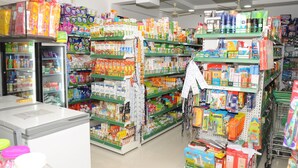 Un pasillo de supermercado con estantes llenos de diversos productos, como aperitivos, bebidas y artículos del hogar.