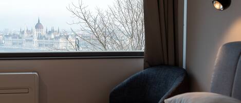 A hotel room with a view of a cityscape, including a prominent building with a dome.