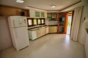Uma cozinha moderna com geladeira, fogão e armários de madeira.
