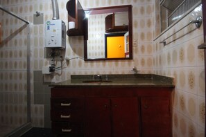 A bathroom with a sink, mirror, and towel rack. - GoHouse Torre 16 (Rio de Janeiro)