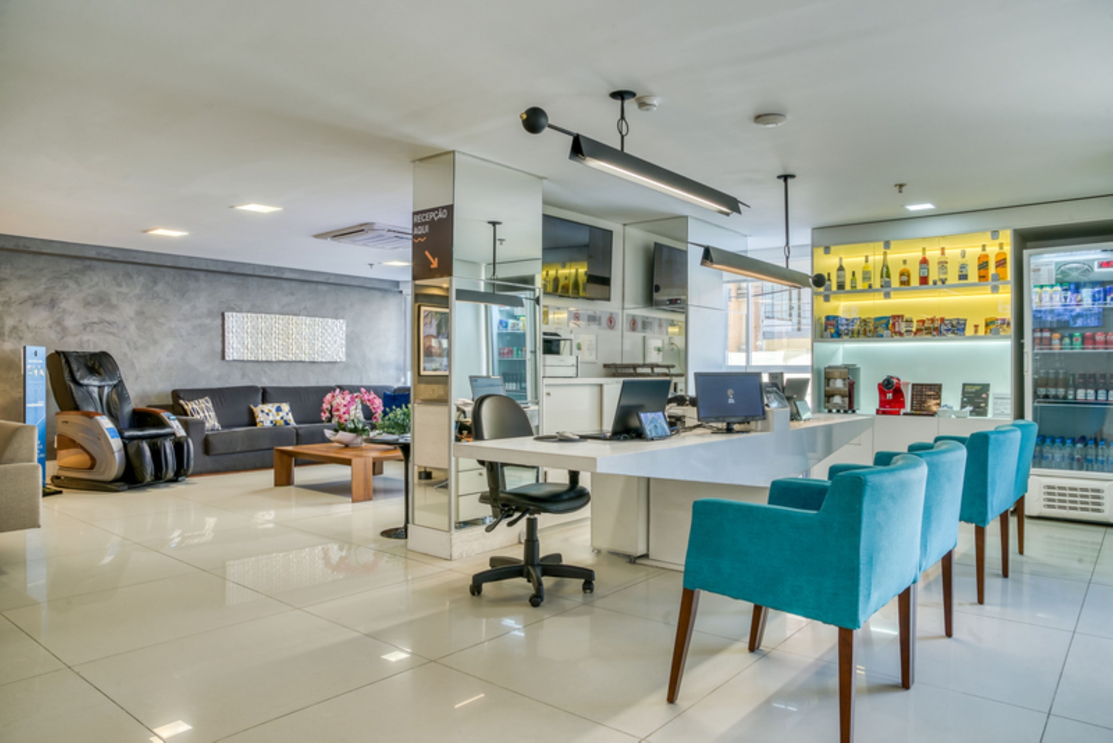Un moderno vestíbulo de hotel con mostrador de recepción, zona de estar y bar.