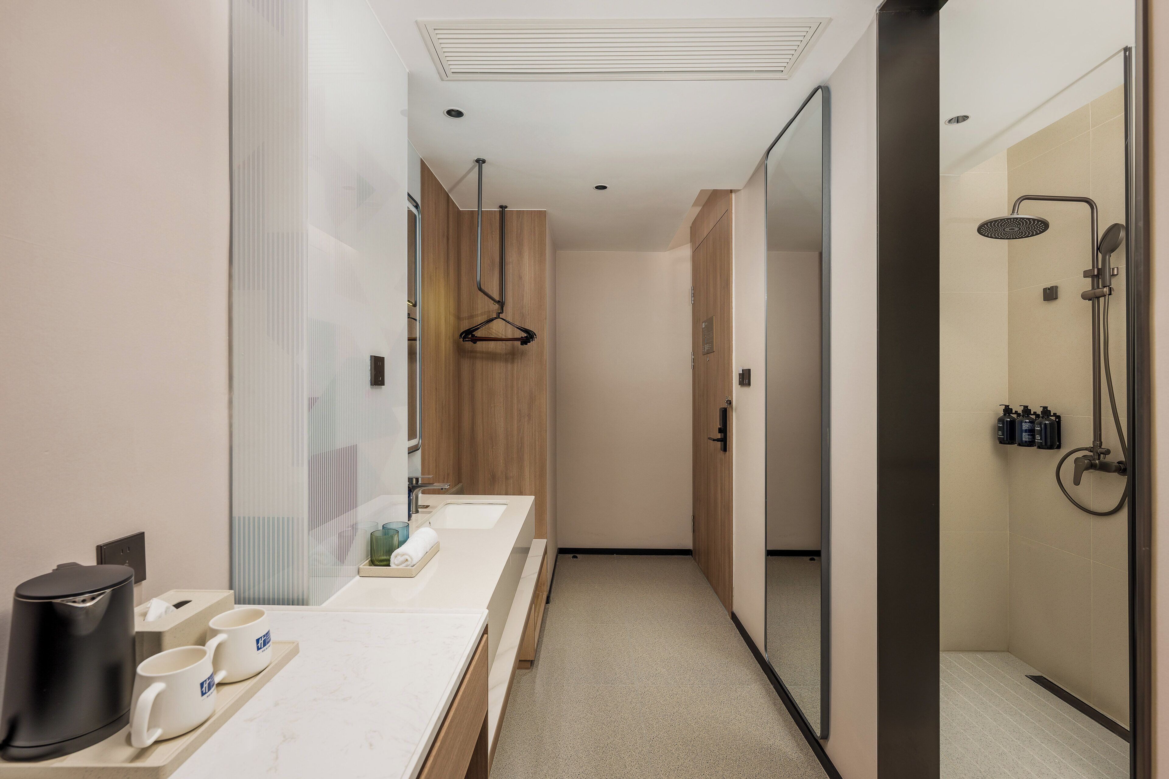 Un baño moderno con un lavamanos espacioso, zona de ducha y espejo.