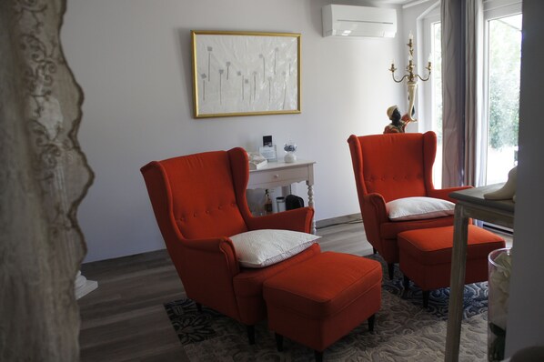 A room with two red armchairs, a small white table, and a framed artwork on the wall. - Le Mas de Cotignac (Cotignac)