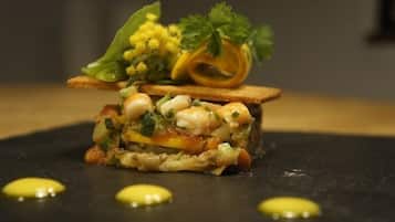 A dish with various vegetables and garnishes on a slate plate.