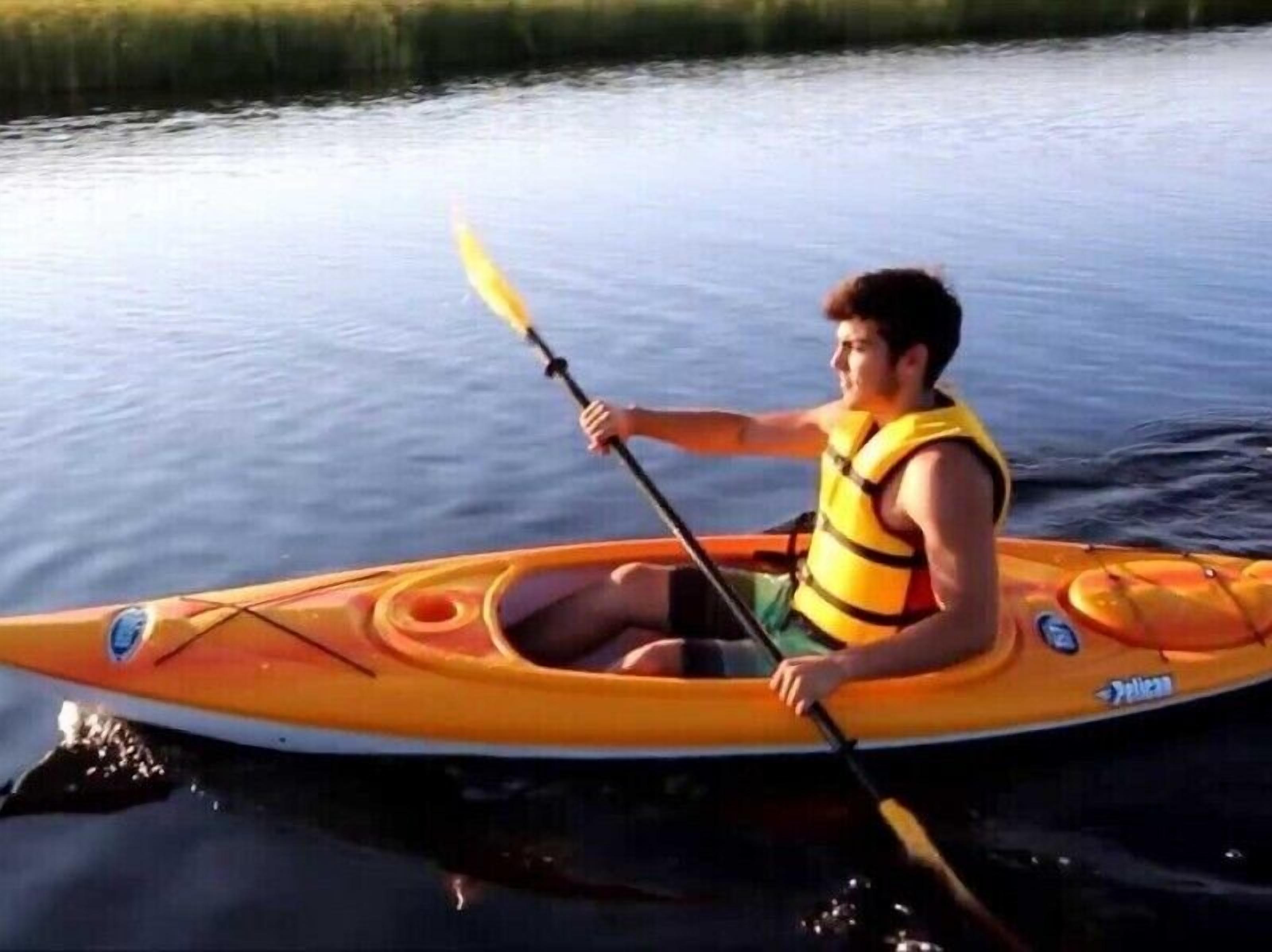 Eine Person sitzt in einem Kajak auf dem Wasser.