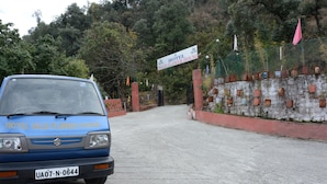 A blue car parked in front of a hotel named "Hotel Wild Flower House." - The Kings Kalindi Resort & Spa (Dhanaulti)