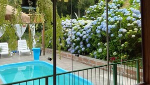 Un espace piscine avec vue sur un jardin et des arbres.
