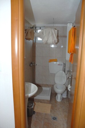 Un baño pequeño con inodoro, bidé y lavamanos.