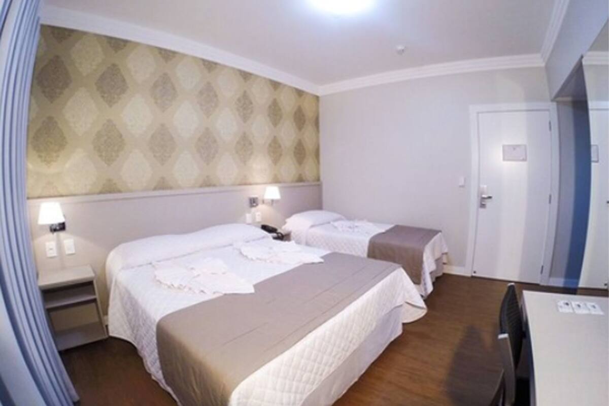 Una habitación de hotel con dos camas, un escritorio y un armario.