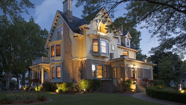 A large, two-story house with a prominent bay window and a wrap-around porch. - Honeybee Inn Bed & Breakfast (Horicon)