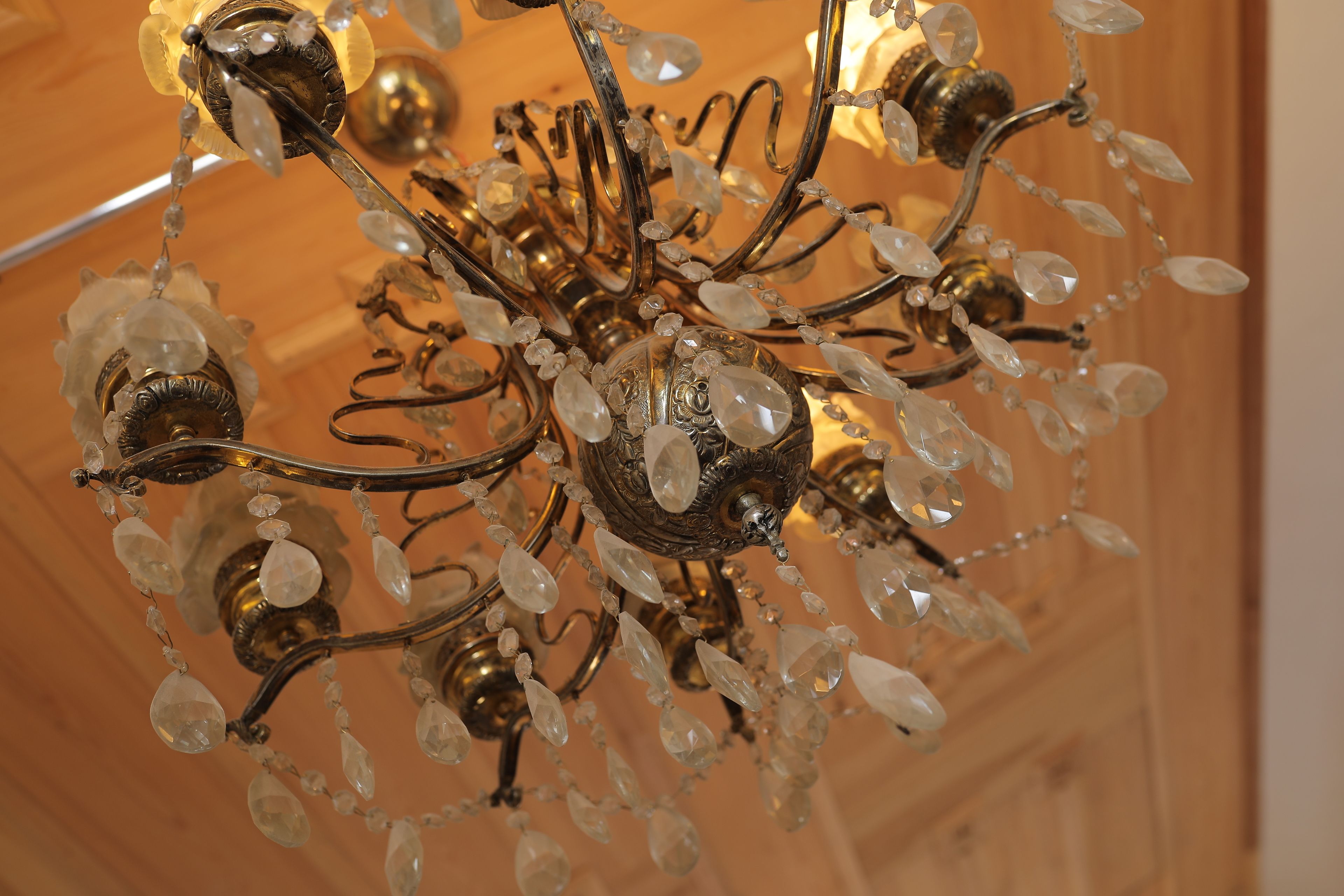 A chandelier with multiple arms and crystal decorations.