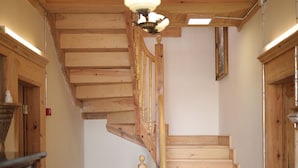 A wooden staircase with a handrail, a ceiling light fixture, and a patterned rug on the floor. - Melekli Konak (Amasya)