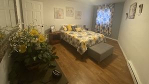 A bedroom with a bed, bedside table, and a mirror. - Auburn Motel (Auburn)