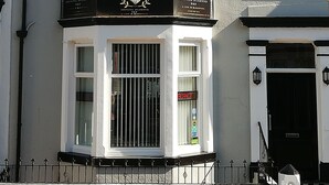 A corner building with a bay window and a black awning. - The Shining Diamond (Blackpool)