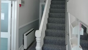 A staircase with carpeted steps and white balusters, leading to an upper floor. - The Shining Diamond (Blackpool)