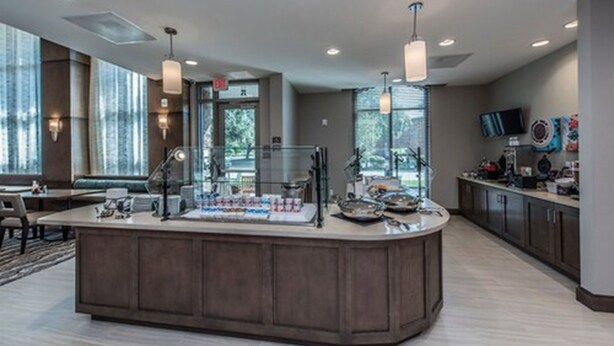 A modern kitchen with a central island, pendant lighting, and a view of the outdoors. - Staybridge Suites Charleston - Mount Pleasant by IHG (Mount Pleasant)