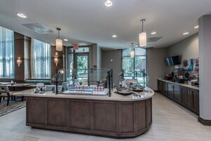 A modern kitchen with a central island, pendant lighting, and a view of the outdoors.