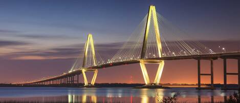 A large suspension bridge with two main towers and cables, spanning over a body of water.