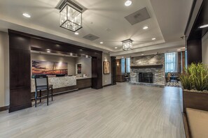 A spacious lobby with a reception desk, a stone fireplace, and a large window. - Staybridge Suites Charleston - Mount Pleasant by IHG (Mount Pleasant)