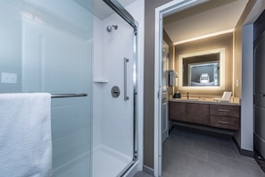 A modern bathroom with a glass shower enclosure, a vanity with a mirror, and a bathtub. - Staybridge Suites Charleston - Mount Pleasant by IHG (Mount Pleasant)
