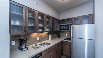 A modern kitchen with stainless steel appliances, wooden cabinets, and a dishwasher.