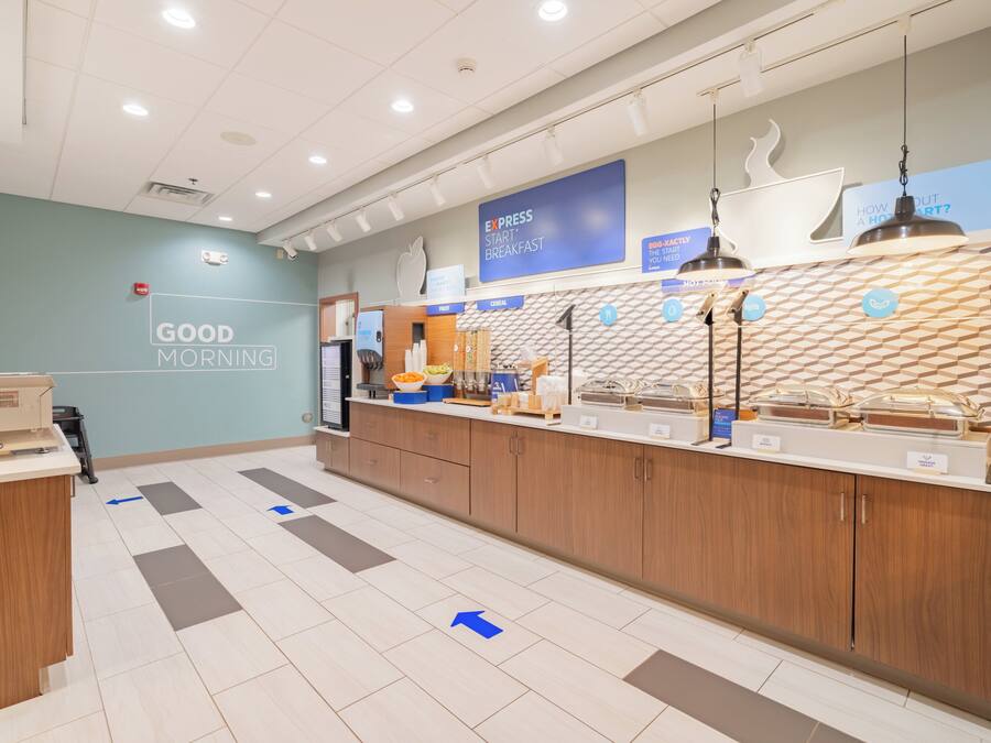 A modern breakfast area with a sign reading "GOOD MORNING" and a counter displaying various food items.