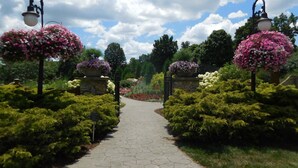 A garden pathway with stone tiles, surrounded by lush greenery and flowering plants. - Holiday Inn Express & Suites Marion by IHG (Marion)