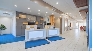 A reception area with two reception desks, a clock, and a plant. - Holiday Inn Express & Suites Marion by IHG (Marion)