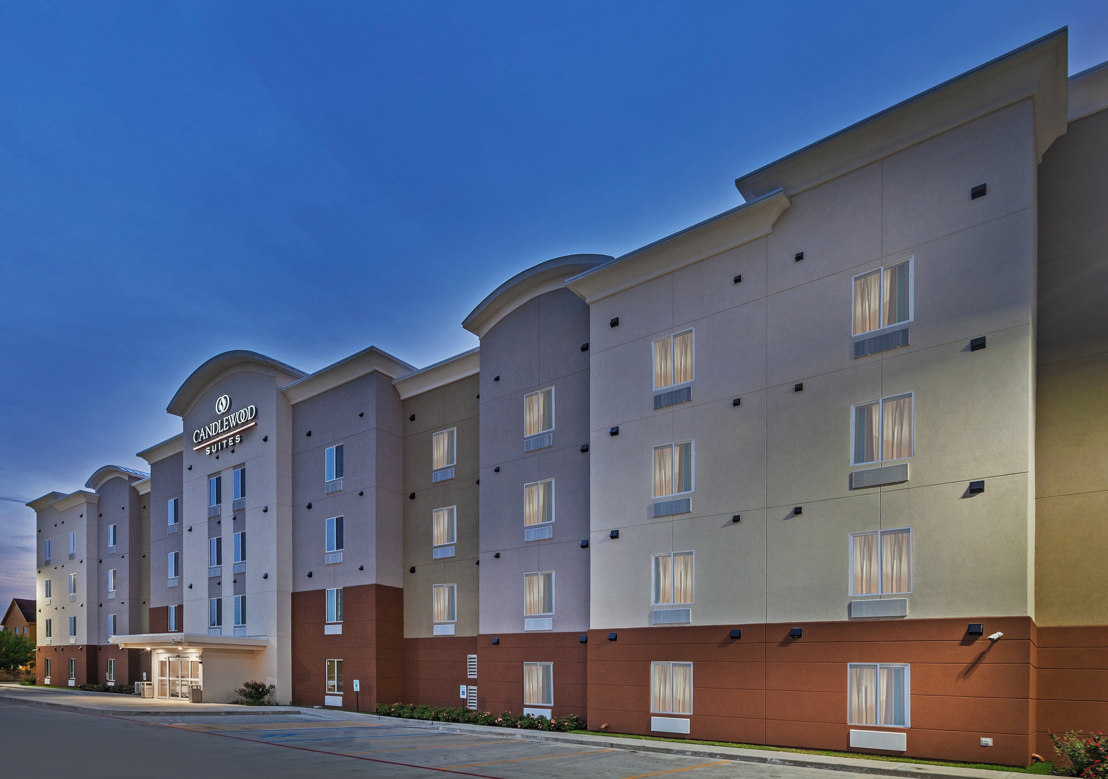 A multi-story hotel with a modern facade, featuring a prominent signage for 'Candlewood Suites.'