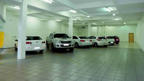 A parking garage with multiple white cars parked in rows.