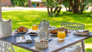 An outdoor breakfast table with croissants, juice, and coffee. - Marina Garden Hotel (Marciana Marina)