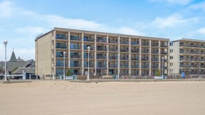Un hotel de varios pisos con balcones, vista a la playa y un cartel que dice 'Virtual Reality'.